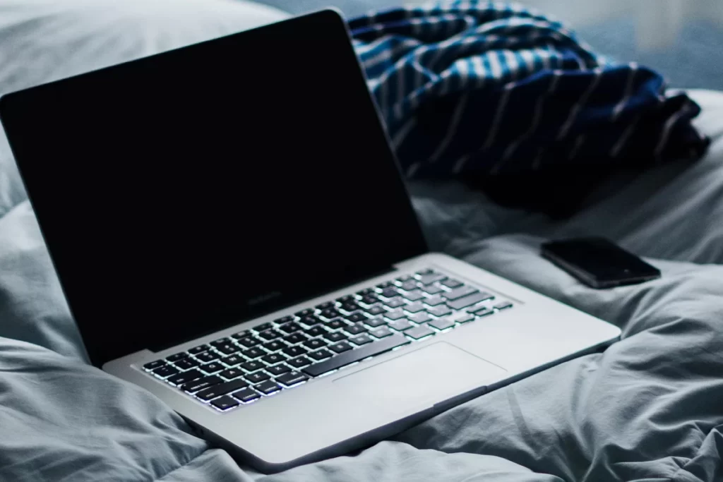 Ordinateur portable Macbook allongé sur le lit